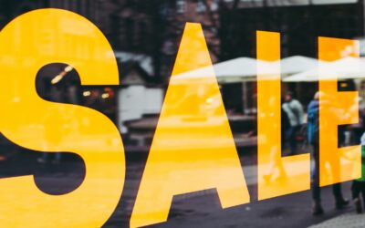 store window with large sale sign painted on it